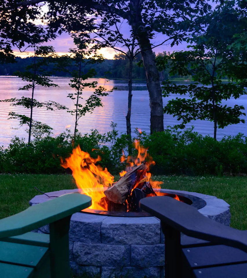 firepit on grassy lawn in front of lake