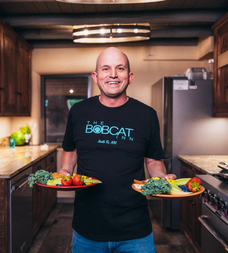 Man holding breakfast plates and smiling